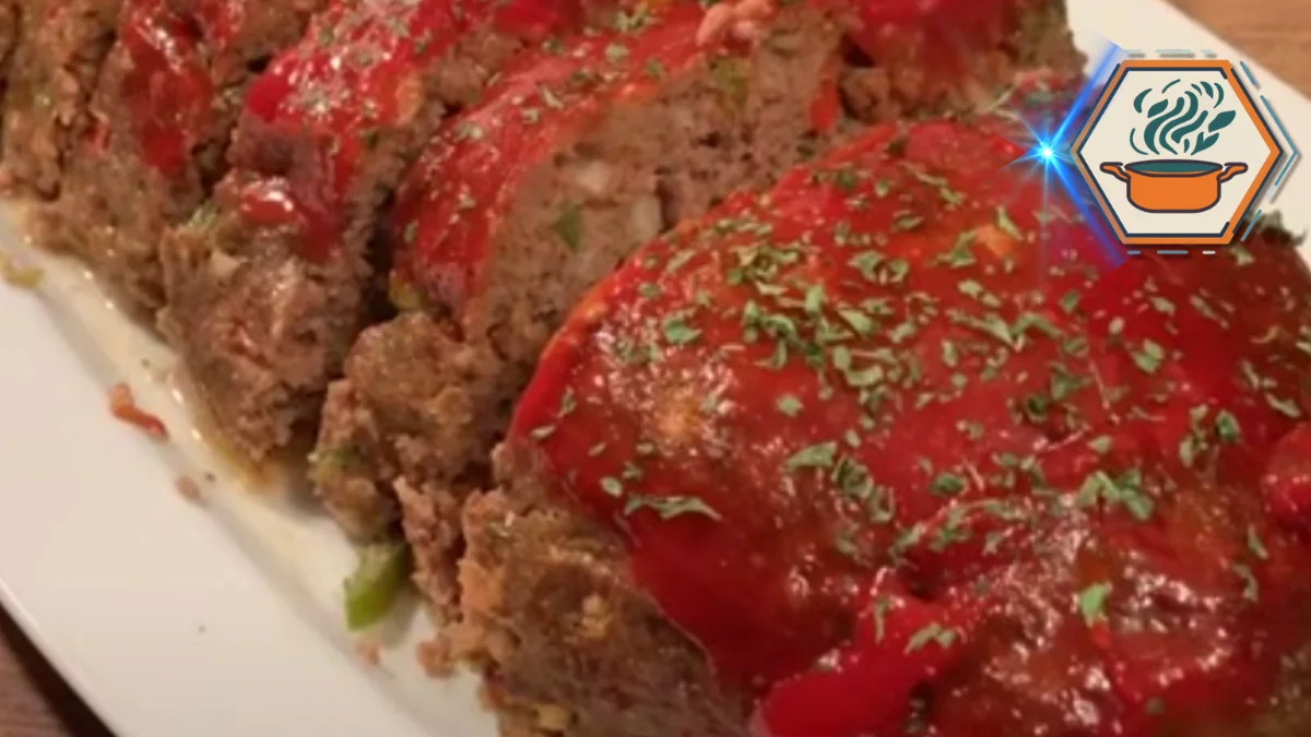 Freshly sliced meatloaf topped with a vibrant tomato glaze and garnished with parsley on a white serving plate