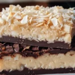 Low side-angle amateur photo of Two-Ingredient Coconut Fudge pieces on a simple plate, showing their soft texture and coconut topping in natural lighting.