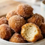 2 Ingredient Donut Holes in a white bowl coated with cinnamon sugar
