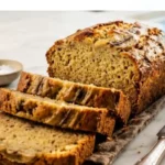 Two-Ingredient Banana Bread sliced on a white marble countertop