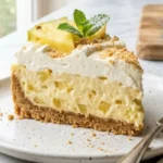 No-Bake Pineapple Cream Dessert slice with pineapple chunks and whipped topping on white marble