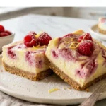 Two-Ingredient Lemon Raspberry Cheesecake Bars on a white marble countertop