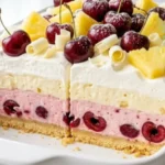 Pineapple Cherry Jubilee Delight in a white baking dish with cherry cheesecake, pineapple cream and whipped topping