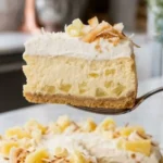 Sugar-Free Creamy Pineapple Cheesecake served on a white marble countertop with whipped cream and fresh pineapple.
