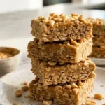 Homemade Two-Ingredient Peanut Butter Oat Bars stacked on a white plate.