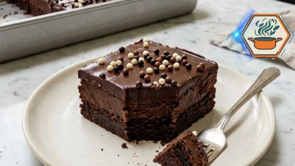 Chocolate Fudge Crunch Tray Bar with glossy ganache and chocolate pearls on a white plate.