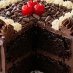 Double Chocolate Celebration Cake with ganache, cream rosettes, chocolate curls and three red cherries