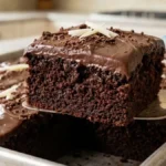 Fudgy chocolate poke sheet cake with glossy chocolate topping in a metal baking pan