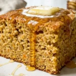 Honey Butter Sweet Potato Cornbread with melting butter and honey on a white marble countertop.