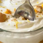 Lemon Peach Cheesecake Cream Lush in a glass dish with peaches and vanilla wafer crumbs