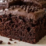 Melt-in-Your-Mouth Chocolate Cake slice with chocolate frosting in a bright American kitchen