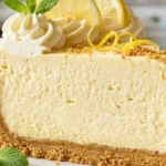 Original Woolworth Cheesecake with whipped cream and lemon garnish.