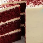 Moist red velvet cake with cream cheese frosting on a white marble countertop