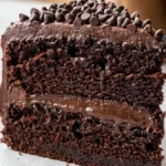 Triple Chocolate Fudge Cake with glossy chocolate frosting and a slice removed