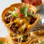 Two-Ingredient Taco Cups with seasoned beef, melted cheddar, lettuce and tomatoes