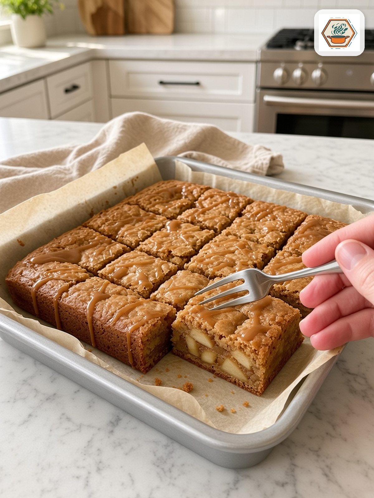 Caramel Apple Blondies Squares – RecipesMind Caramel apple blondies cut into 16 squares with a fork lifting one to show the apple pieces inside